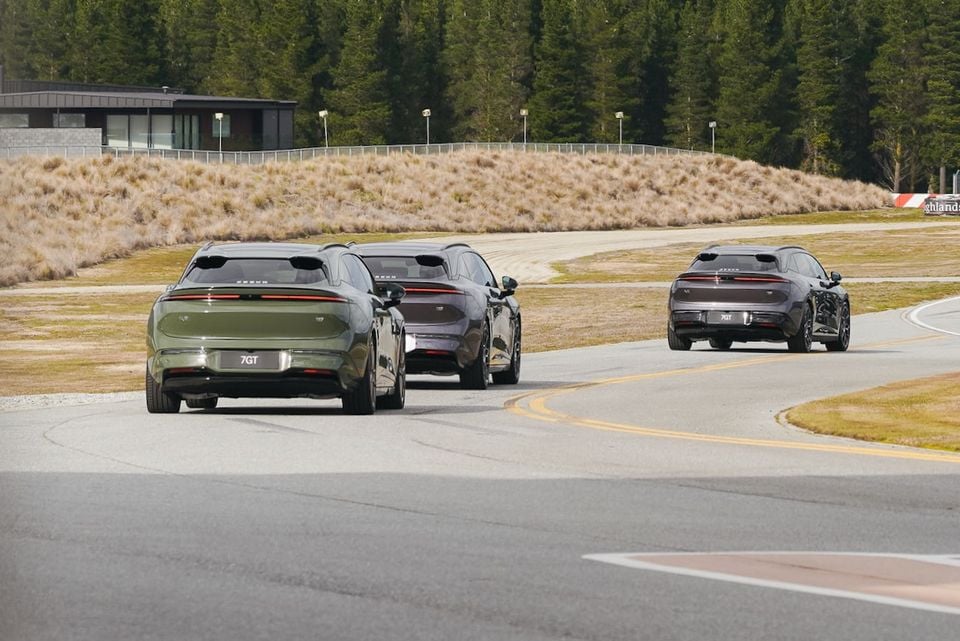 Three Zeekr 7GT wagons seen from the rear driving on a track, in green and dark grey colours