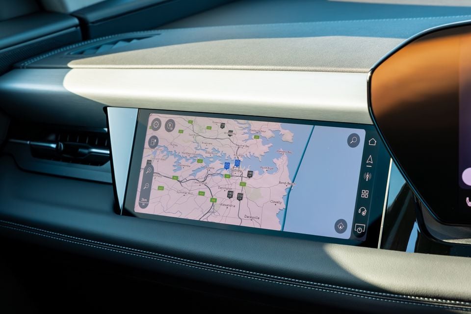 Close-up of the infotainment touchscreen inside a 2027 Audi Q6 e-tron, displaying a navigation map centred on Sydney, Australia