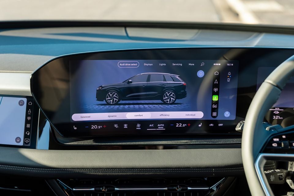 The Audi drive select menu displayed on the large curved infotainment touchscreen inside an Audi Q6 e-tron, showing drive modes including comfort, dynamic, balanced, efficiency and individual, along with climate control settings.