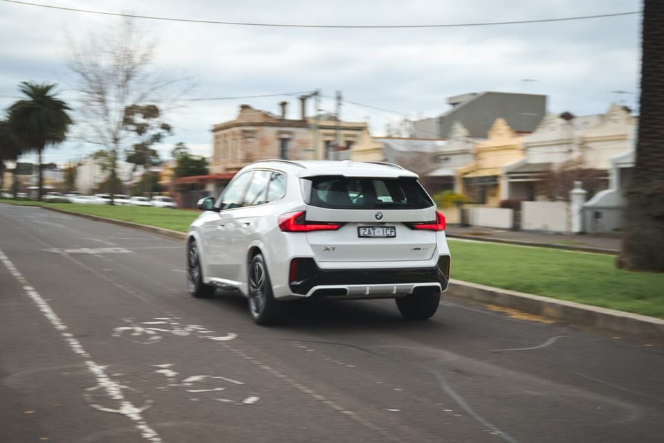 A white BMW X1 SUV seen from the rear while driving along a suburban Melbourne street