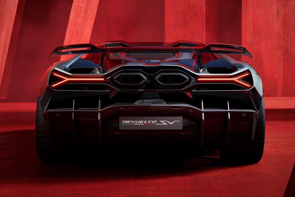 Rear view of a Lamborghini Revuelto SV supercar with angular LED taillights, quad exhaust outlets, and a large rear wing, set against a red backdrop.