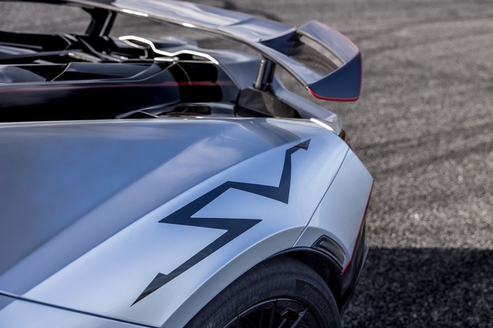 Close-up of the rear quarter panel and large rear wing of a silver Lamborghini Revuelto SV, showing bold angular graphic details on the bodywork