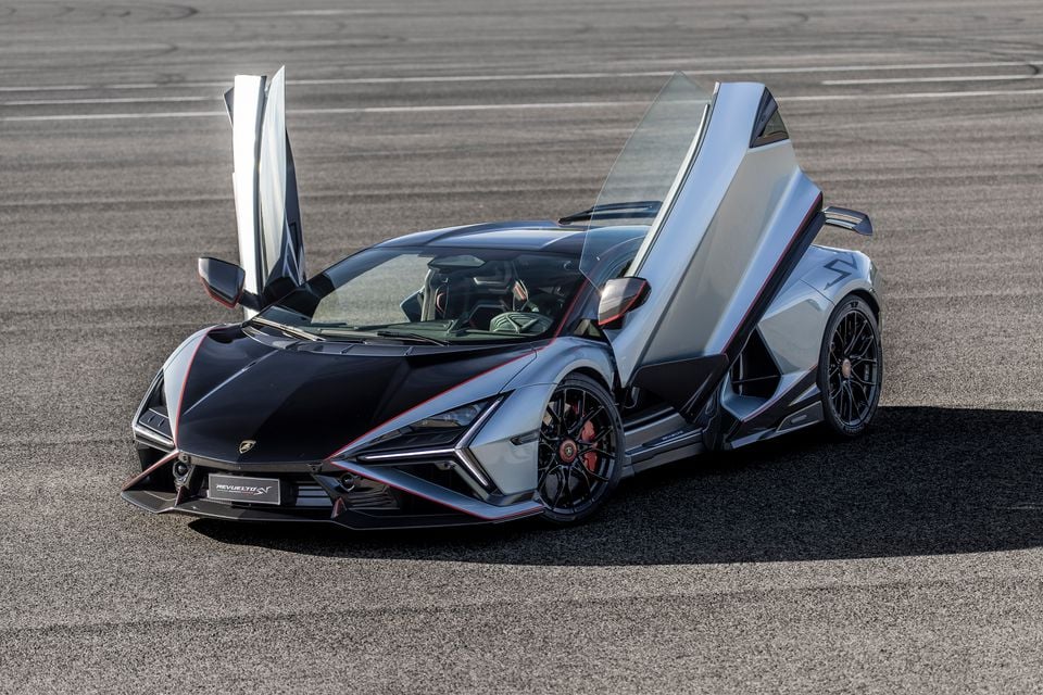 A Lamborghini Revuelto SV supercar with scissor doors open, seen from the front-side angle on a tarmac surface