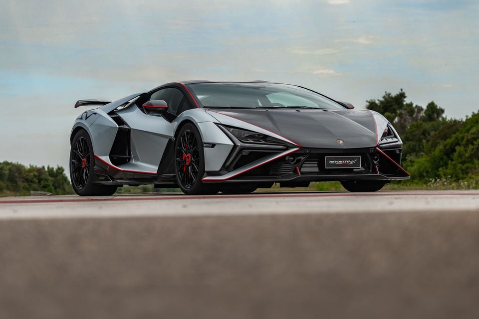 A Lamborghini Revuelto SV supercar in grey and black with red accents, seen from the front three-quarter angle on a road.