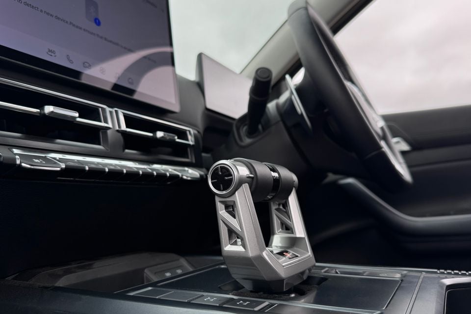 Close-up of the gear shifter and steering wheel inside a 2027 LDV T60 Luxe, with the infotainment screen visible in the background