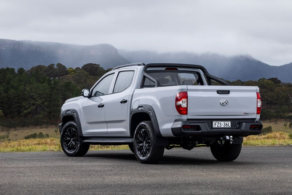 A silver 2027 LDV T60 dual-cab ute parked on a road, seen from the rear quarter with mountains in the background