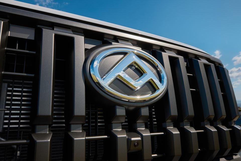 Close-up of the LDV badge on the front grille of a 2027 LDV T60 Luxe ute, with a blue sky in the background