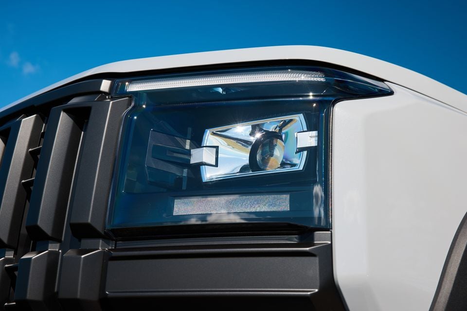 Close-up of the headlight on a white 2027 LDV T60 Luxe ute, with a dark grille and bull bar visible alongside.