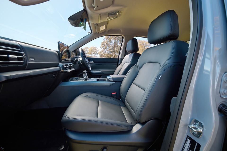 The black leather front seats and dashboard of a 2027 LDV T60 Luxe dual-cab ute, viewed from the driver's door