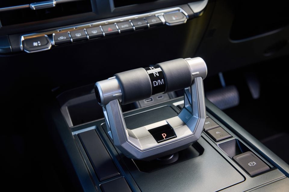 A close-up of the unique gear selector and climate control buttons inside a 2027 LDV T60 Luxe ute, with gear positions R, N and D/M labelled on the handle.