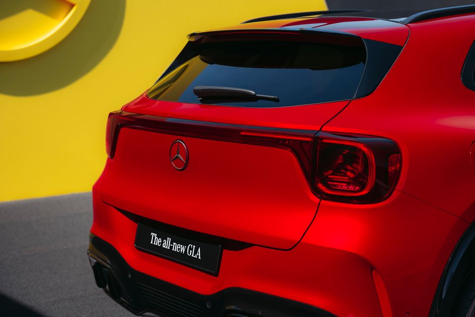 Rear view of a red Mercedes-Benz GLA SUV, showing the tail lights, Mercedes star badge, and a number plate reading 'The all-new GLA'