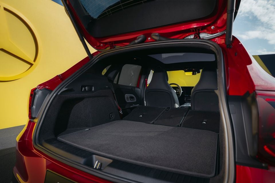 Boot of a red Mercedes-Benz GLA open wide with rear seats folded flat, showing a large carpeted load area.