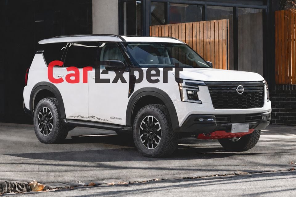 A white Nissan Patrol Y63 Warrior SUV seen from the front-side, featuring all-terrain tyres, black alloy wheels, a red recovery hook, and Warrior graphics on the door