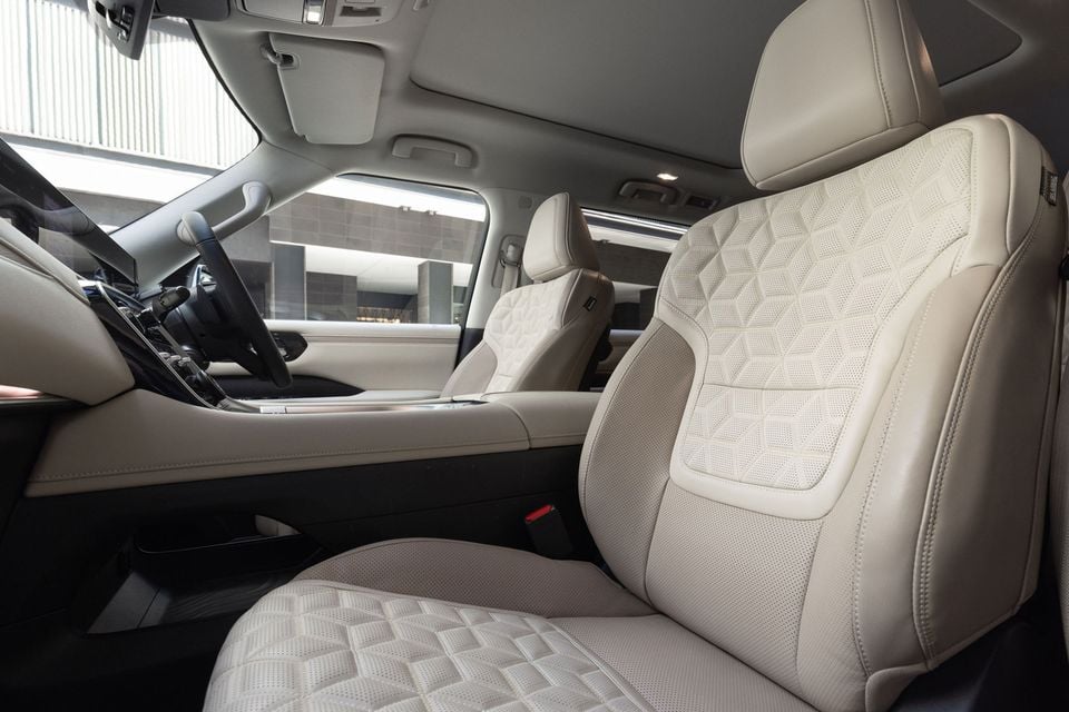 Cream leather front seats with geometric quilted stitching inside a Nissan Patrol Y63, with the steering wheel and centre console visible