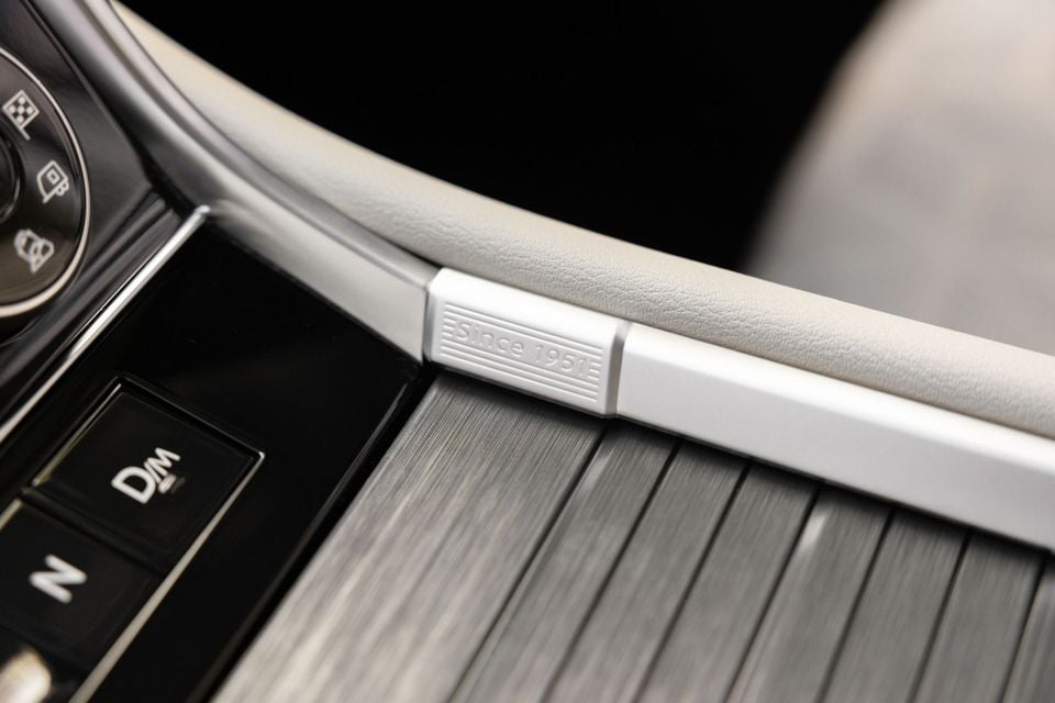 Close-up of a 'since 1951' embossed silver trim detail on the centre console of a 2027 Nissan Patrol Y63, with brushed metal trim and gear selector buttons visible nearby.