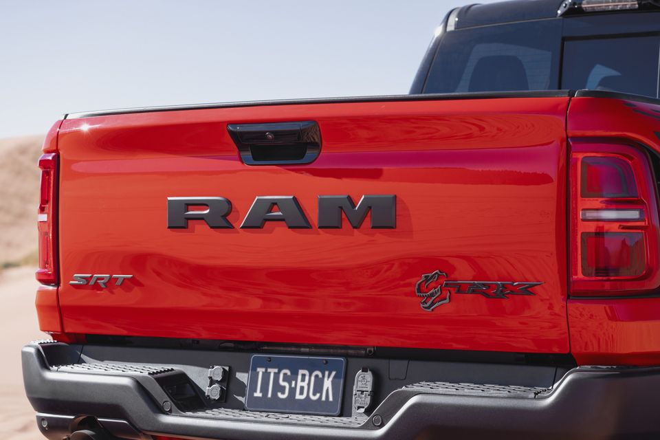 Close-up of the red Ram 1500 TRX SRT ute's tailgate, showing RAM lettering and TRX badge, with a number plate reading ITS BCK