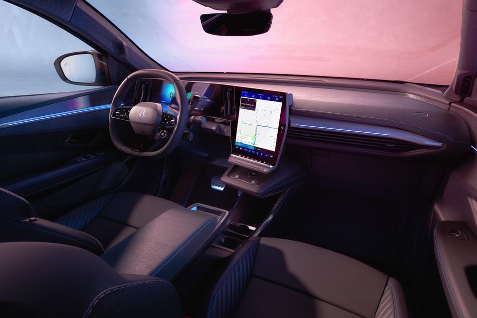 Interior of a Renault Scenic E-Tech Electric showing the dashboard, large central touchscreen displaying navigation, steering wheel, and front seats with blue ambient lighting