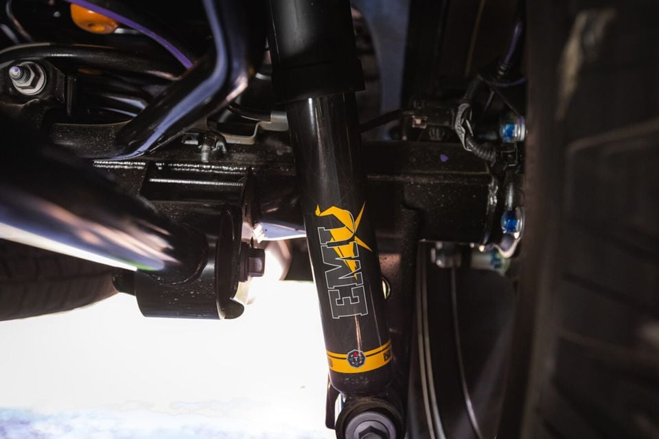 Close-up of an EMU brand shock absorber fitted to the underside suspension of a 2027 Toyota Tundra TralHunter, viewed from below