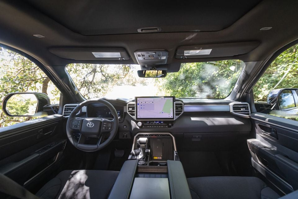 Interior of a Toyota Tundra showing the dashboard, large central touchscreen displaying navigation, steering wheel with Toyota logo, and centre console