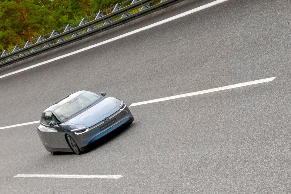 A Volkswagen ID. Mission Efficiency concept car driving on a highway, seen from above and slightly in front