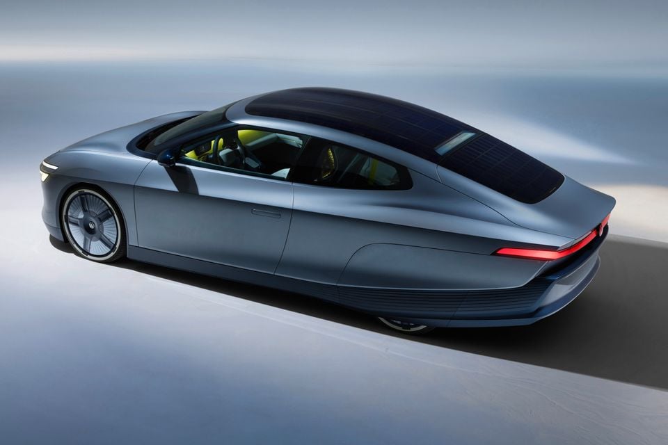 A Volkswagen Mission Efficiency concept car in matte grey, seen from a high rear-side angle, showing its sleek fastback body and solar panel roof
