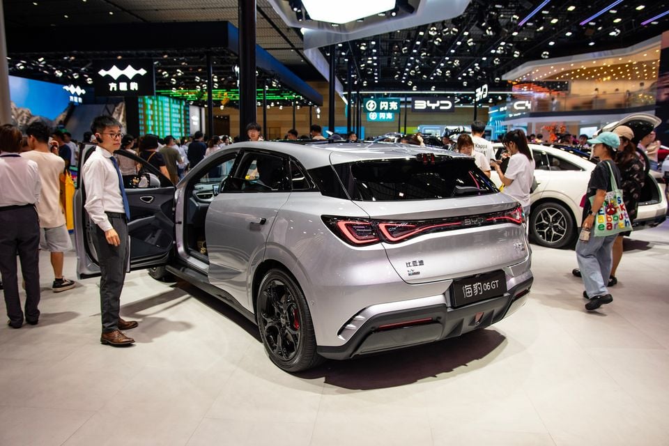 A silver BYD Seal 06 GT hatchback displayed from the rear three-quarter angle at the Chengdu Motor Show, surrounded by attendees