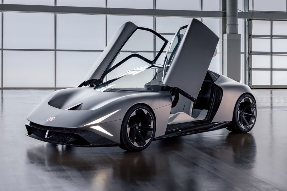 An Acura concept car with scissor doors open, shown from the front-side in a modern indoor space