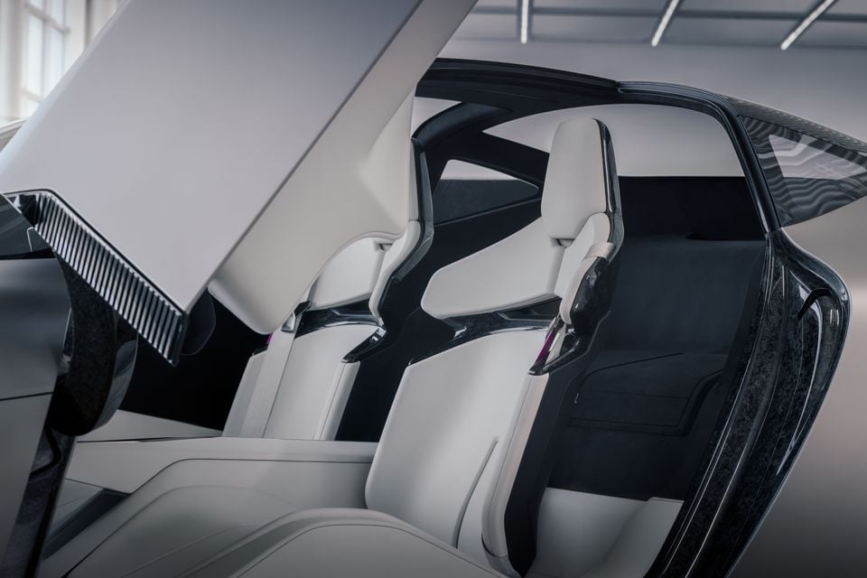 Interior of the Acura Nexera Vision concept car showing two sculpted white bucket seats with dark carbon-fibre accents, viewed through an open gull-wing style door