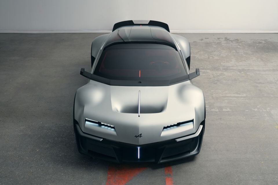 Um carro esportivo conceito Alpine A310 Vision prateado visto de cima e de frente, estacionado em um piso de concreto