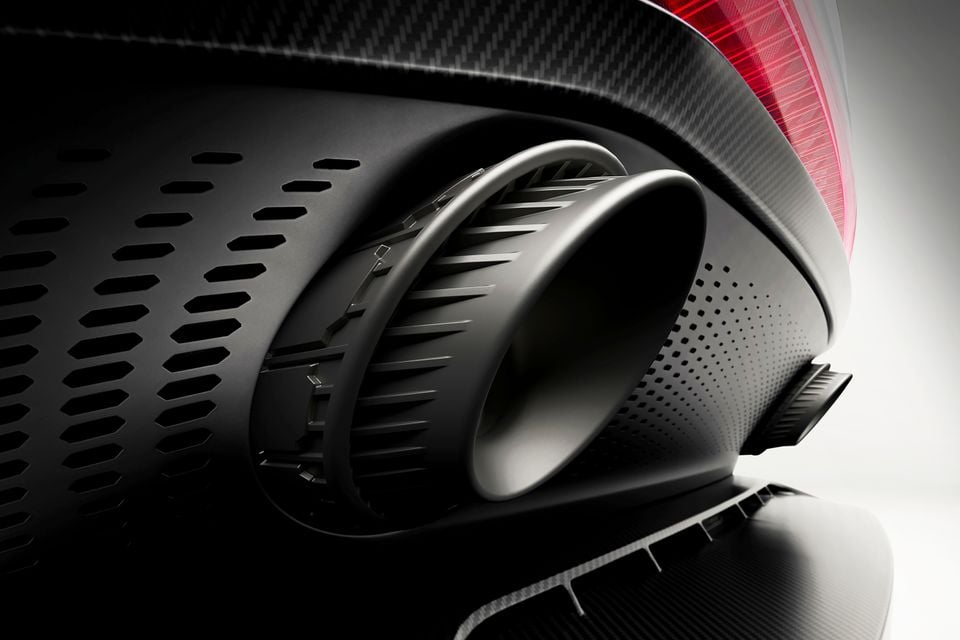 Close-up of the rear diffuser and exhaust outlet on an Aston Martin Valen, showing carbon fibre trim and tail light detail