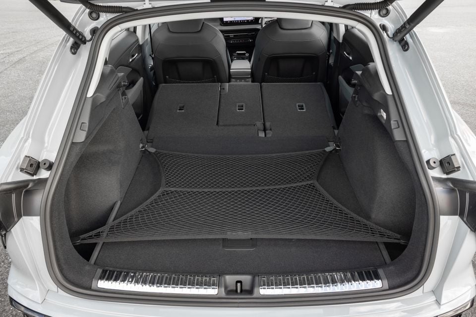 Open boot of an Audi Q3 SUV showing a spacious cargo area with a cargo net and folded rear seats visible through the opening