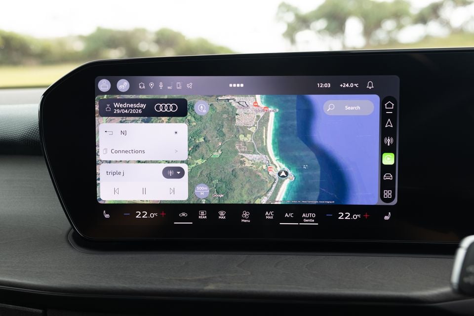 The infotainment touchscreen of an Audi Q3 displaying a Google Maps navigation view alongside media controls showing triple j radio and climate control settings at the bottom