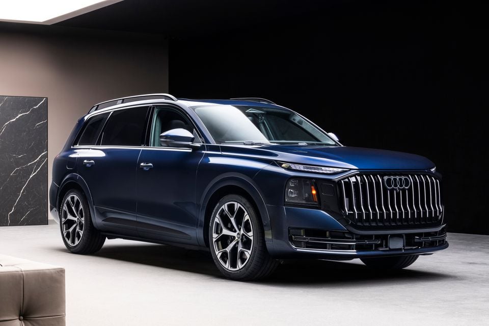 A blue 2026 Audi Q9 large SUV photographed from the front three-quarter angle in a studio setting