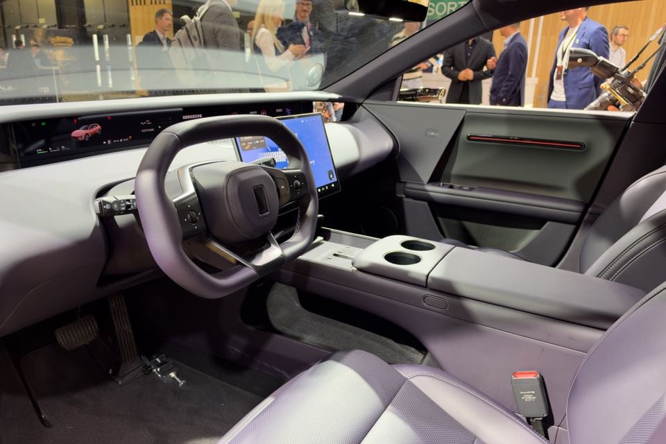 Grey interior of the Avatr 06T showing a yoke-style steering wheel, wide digital dashboard display, central touchscreen and front seats at a motor show