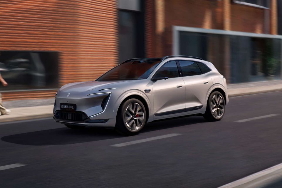 A silver Avatr 07L electric SUV driving along a city street, seen from the front quarter