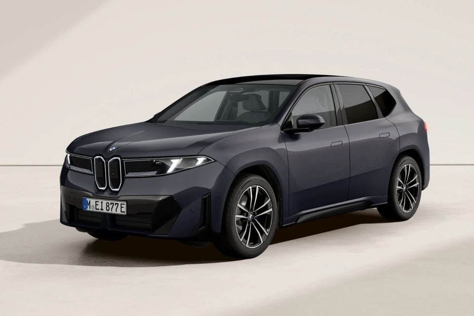 A dark blue BMW iX3 SUV seen from the front-side angle against a neutral studio background