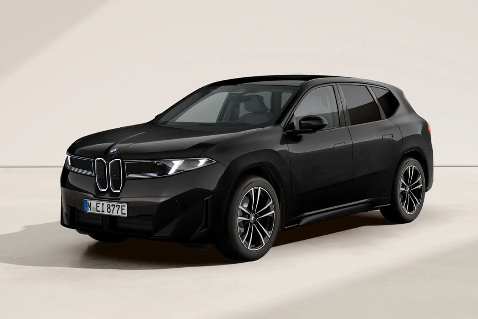 A black BMW iX3 SUV shown from the front-side angle against a neutral studio background