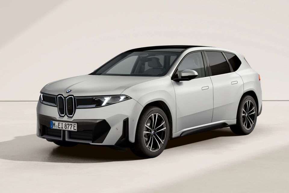 A silver BMW iX3 electric SUV seen from the front-side angle against a neutral studio background