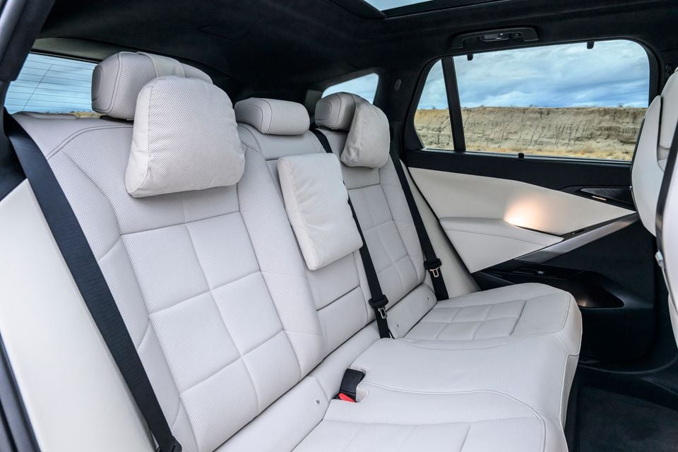 Rear seats of the BMW iX5 60 xDrive with light grey perforated leather upholstery and cushioned headrest pillows