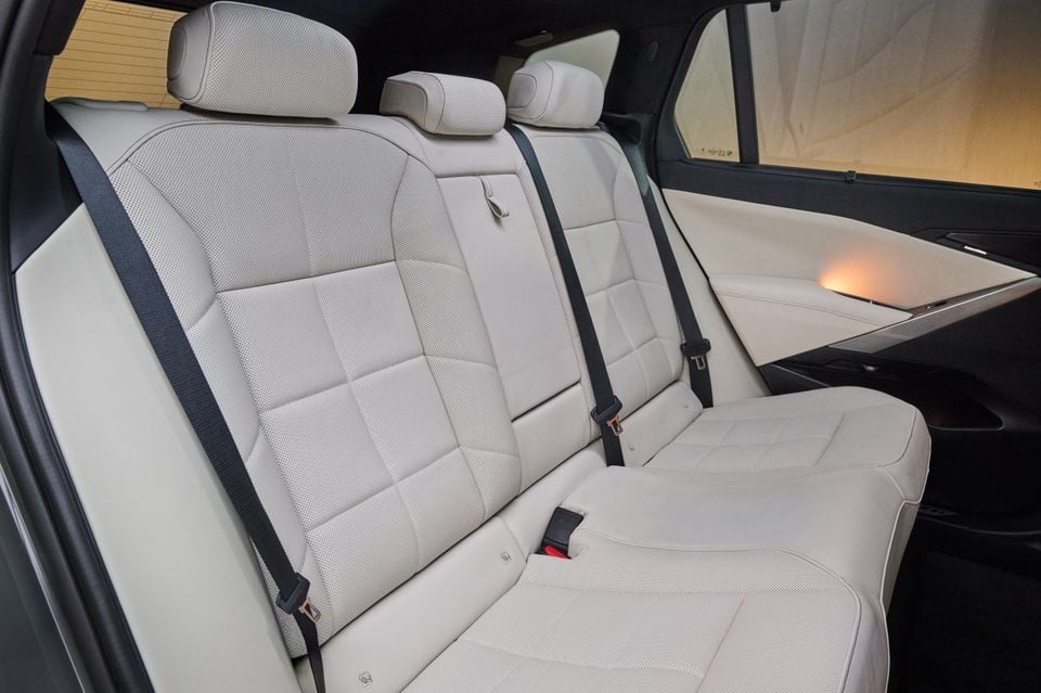 Light grey leather rear seats of a BMW X5 SUV, showing three headrests, seatbelts, and perforated upholstery detail