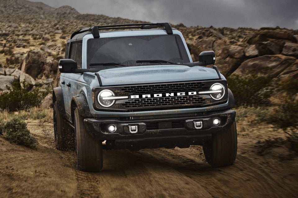 Blue-grey Ford Bronco viewed from the front on a rocky off-road trail