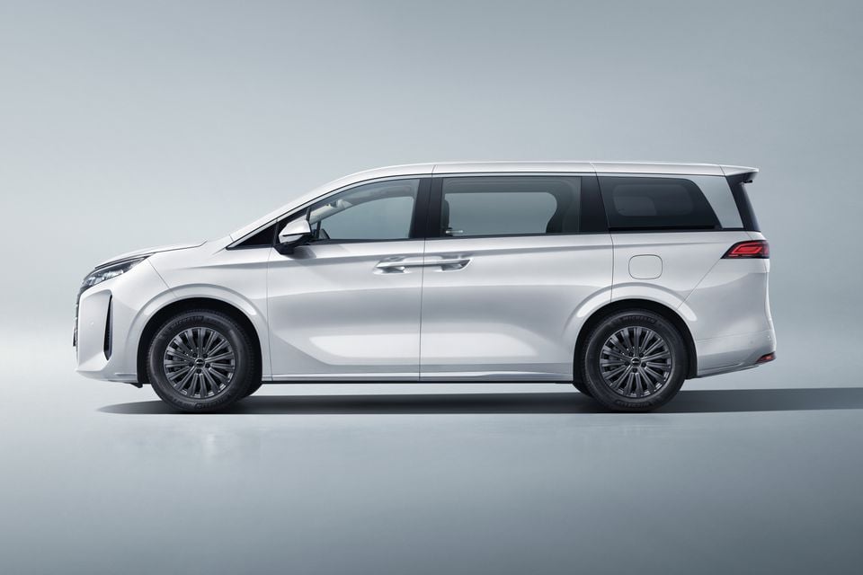 A white BYD M9 people mover van photographed from the side in a studio setting