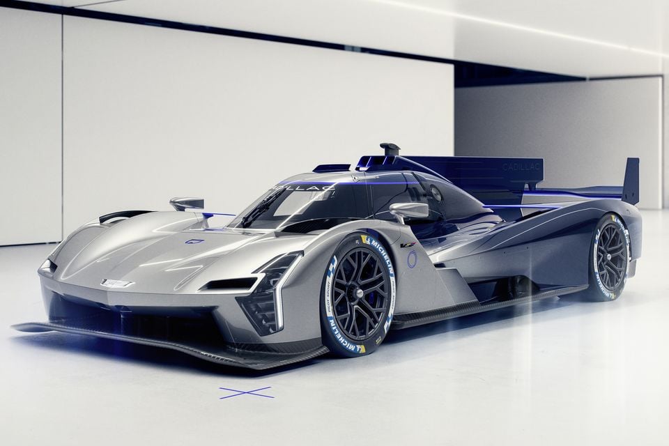 The Cadillac GTP Hypercar concept racing car seen from the front-side, finished in silver and dark blue with Michelin racing tyres, displayed indoors.