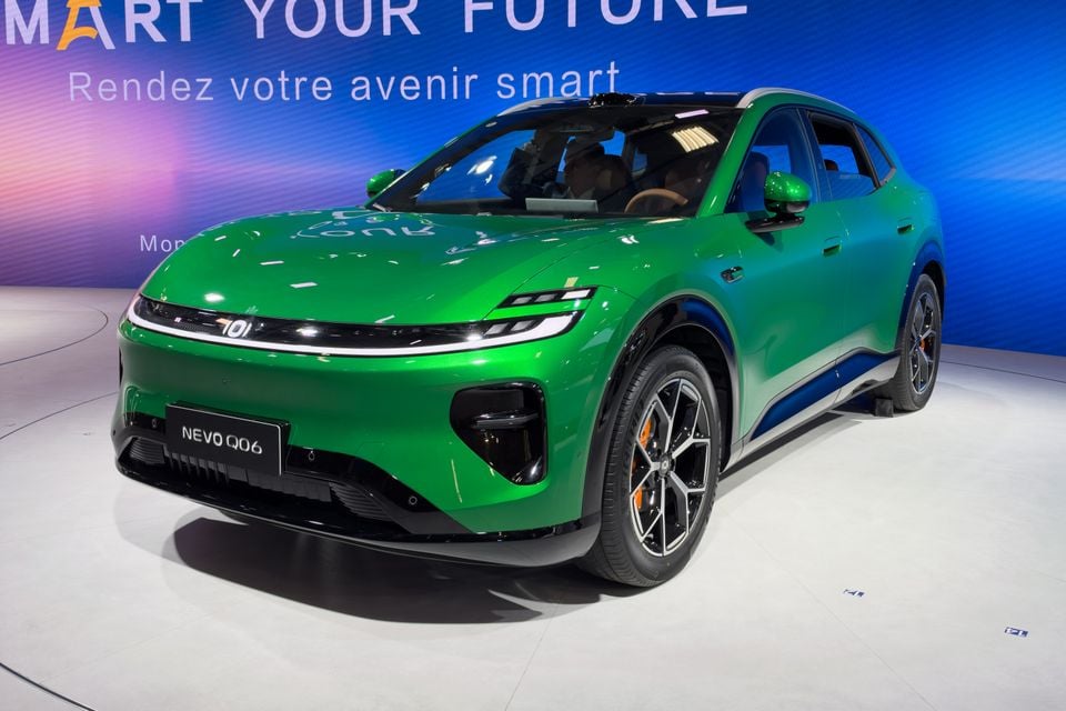 A green Changan Nevo Q06 electric SUV on display at a motor show, seen from the front three-quarter angle.
