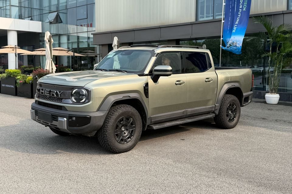 Khaki Chery Stockman dual-cab ute viewed from the front quarter outside an event venue.