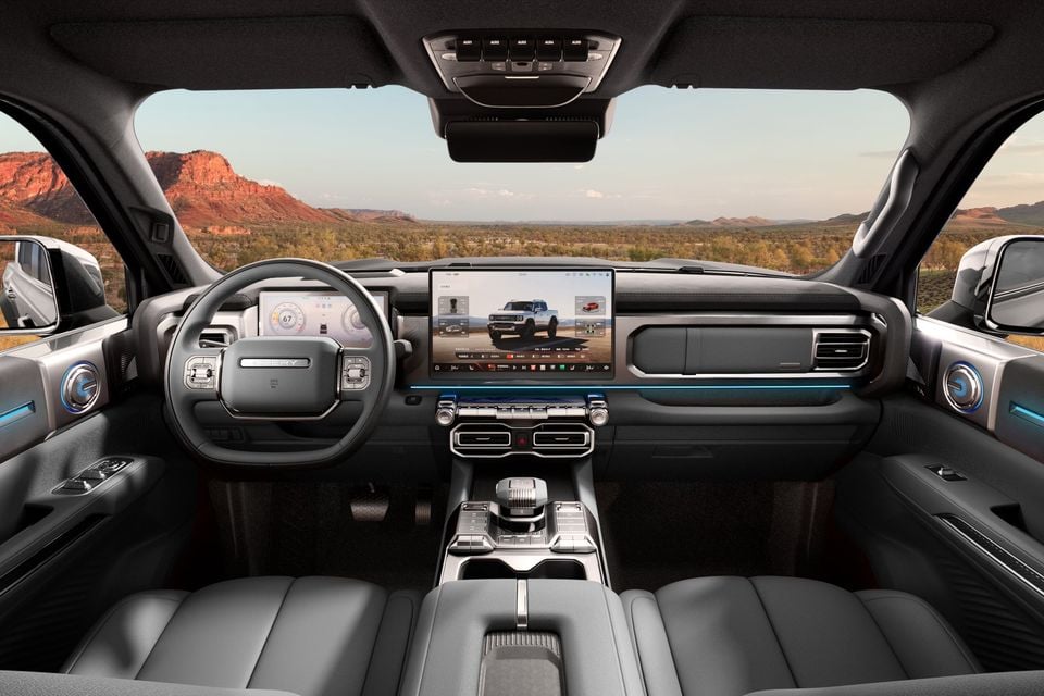Illustrative Stockman cabin image showing a left-hand-drive steering wheel, dashboard and central touchscreen.