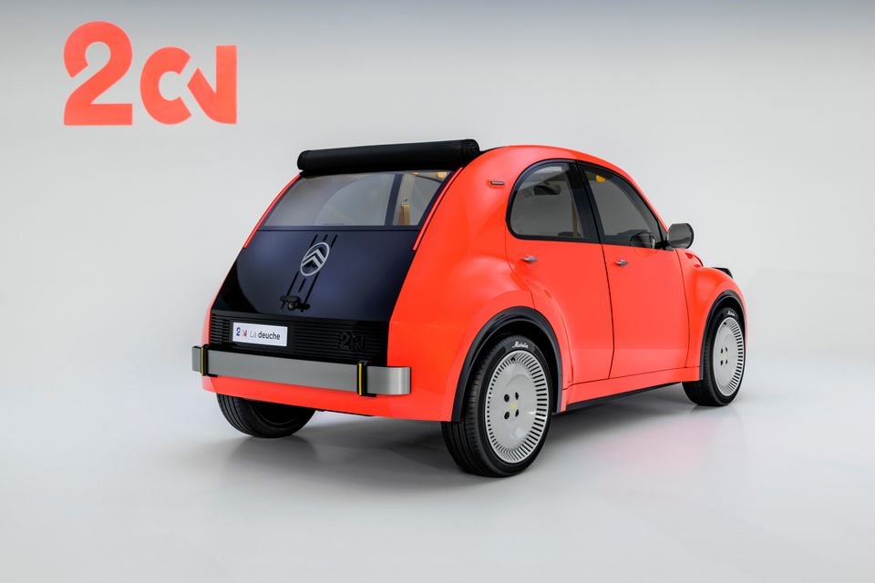 An orange Citroën 2CV concept hatchback seen from the rear quarter in a studio, with a black tailgate and roll-back fabric roof