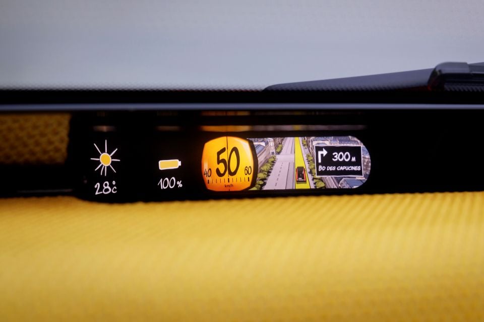Slim digital instrument display in the Citroen 2CV concept showing a 50km/h speed gauge, comic-style navigation map, 28°C temperature and 100% battery
