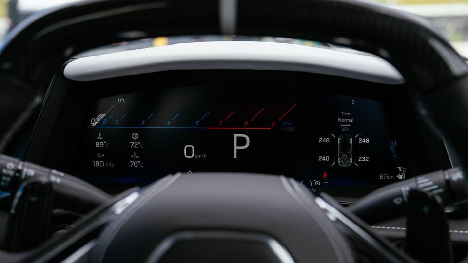 Close-up of the digital instrument cluster in a Chevrolet Corvette Z06, showing the tachometer, speed, gear position and tyre pressure display, viewed through the steering wheel.
