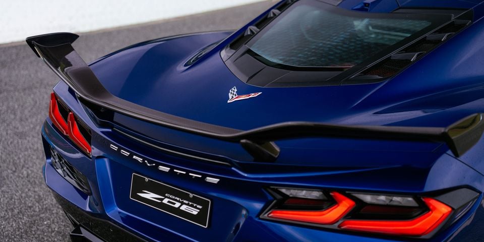 A close-up of the rear end of a blue Chevrolet Corvette Z06, showing its carbon-fibre spoiler, taillights and badge.